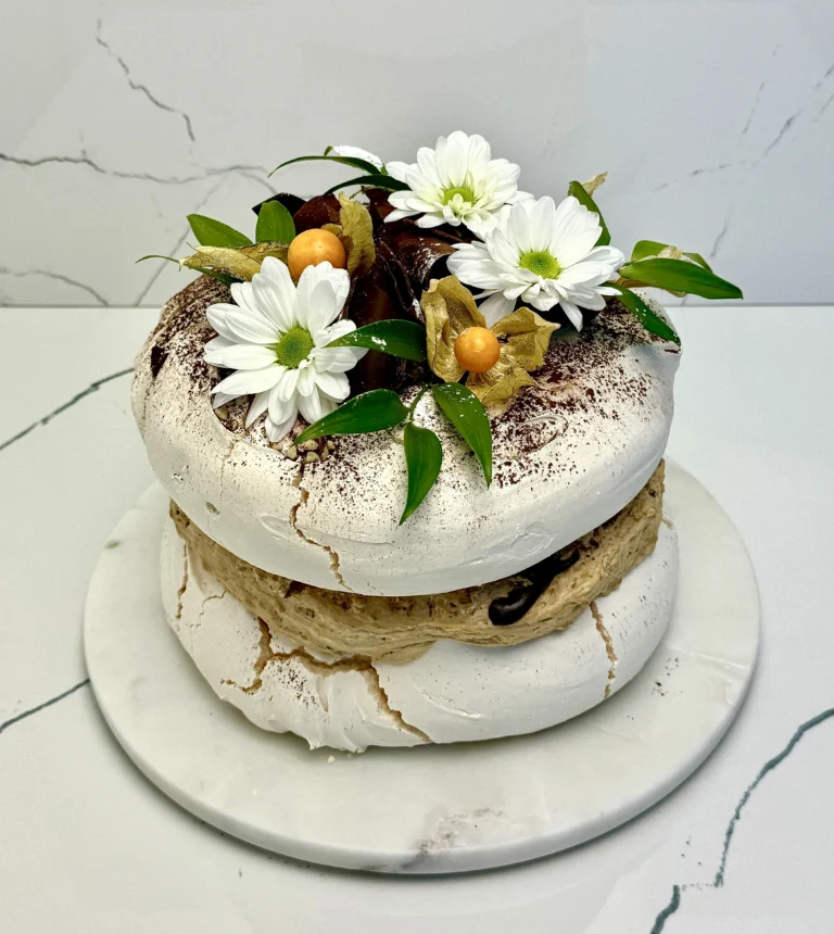 Zdjęcie przedstawia tort bezowy Rocher możliwy do zamówienia przez sklep cukierni Bezownia znajdującej się w Warszawie, ul. F. Joliot-Curie 11