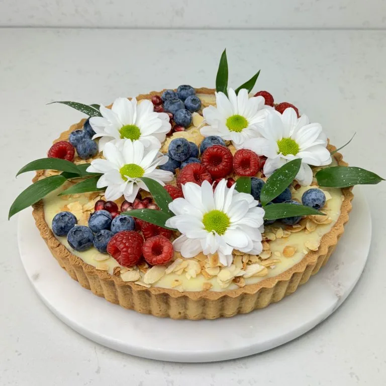 Zdjęcie tarty z białą czekoladą i czarną porzeczką - możliwa do zamówienia przez sklep cukierni Bezownia znajdującej się w Warszawie, ul. F. Joliot-Curie 11