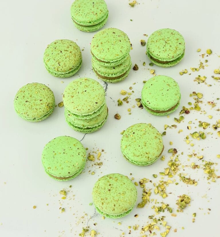 Zdjęcie przedstawia makaroniki pistacjowe możliwe do zamówienia przez sklep cukierni Bezownia znajdującej się w Warszawie, ul. F. Joliot-Curie 11