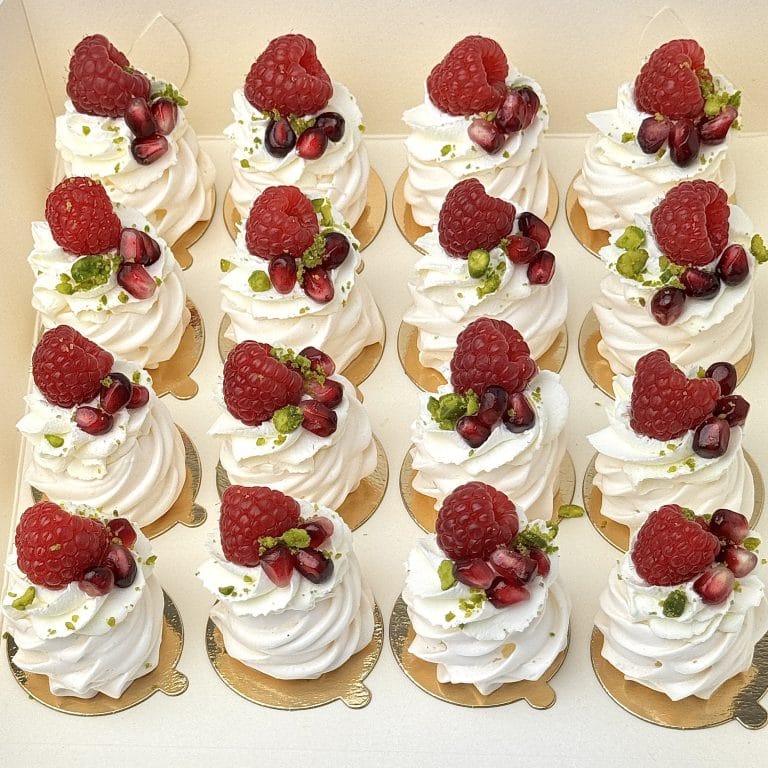 Zdjęcie przedstawia zestaw 16 mini bezików z owocami - zestaw możliwy do zamówienia przez sklep cukierni Bezownia znajdującej się w Warszawie, ul. F. Joliot-Curie 11.