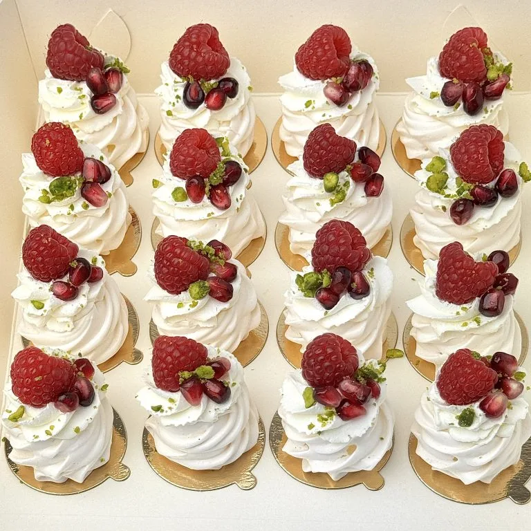 Zdjęcie przedstawia zestaw 16 mini bezików z owocami - zestaw możliwy do zamówienia przez sklep cukierni Bezownia znajdującej się w Warszawie, ul. F. Joliot-Curie 11.