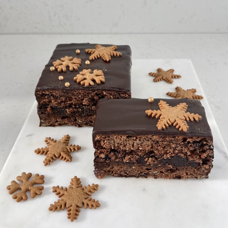 Zdjęcie przedstawia piernik przekładany powidłami śliwkowymi i oblany czekoladą. Piernik możliwy jest do zamówienia przez sklep cukierni Bezownia znajdującej się w Warszawie, ul. F. Joliot-Curie 11.