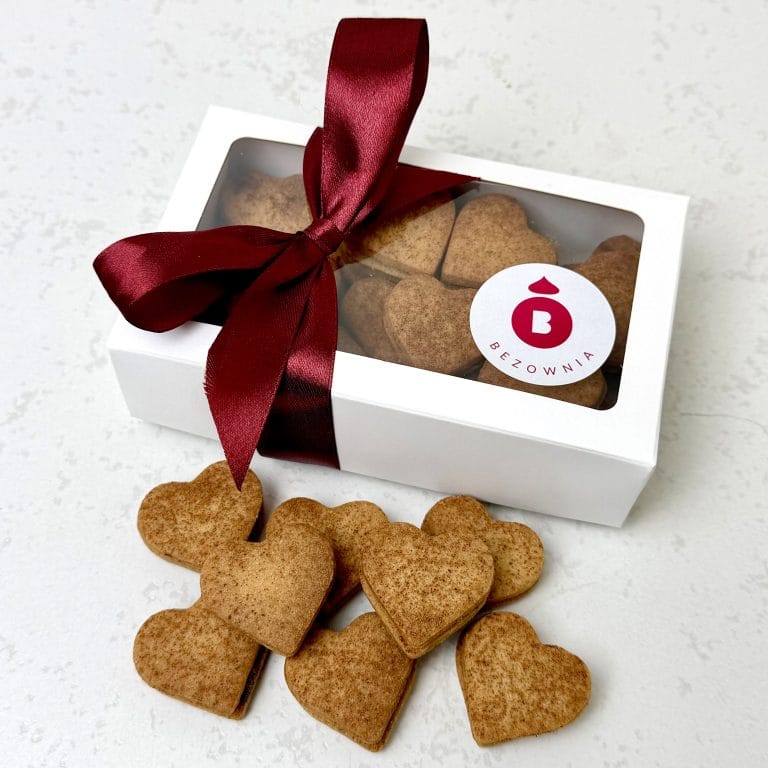 Zdjęcie przedstawia kruche ciasteczka cynamonowe przełożone powidłami śliwkowymi. Ciasteczka można zamówić przez sklep cukierni Bezownia znajdującej się w Warszawie, ul. F. Joliot-Curie 11.