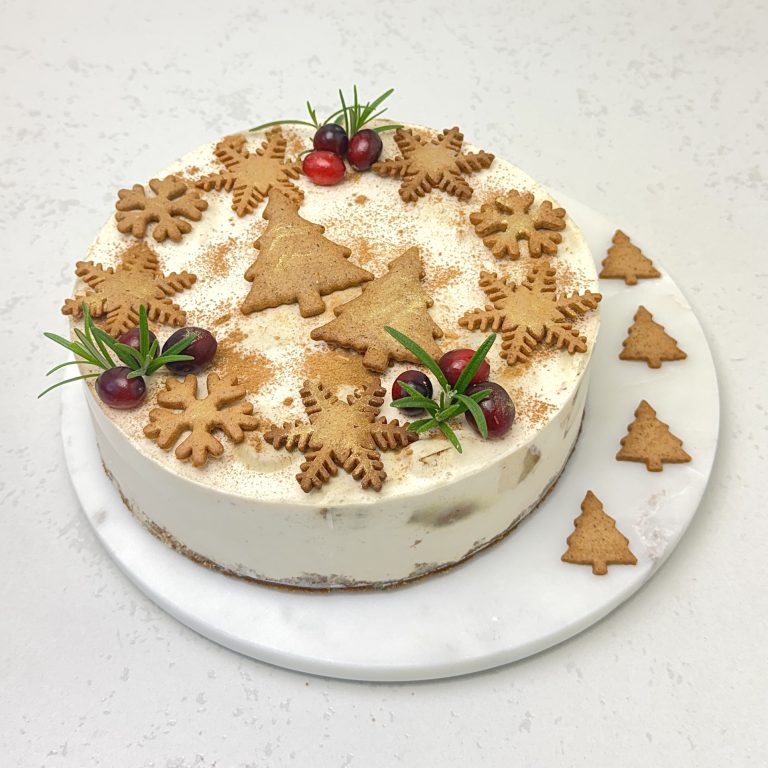 Zdjęcie przedstawia okrągły sernik na zimno cynamonem i pierniczkami. Sernik możliwy jest do zamówienia przez sklep cukierni Bezownia znajdującej się w Warszawie, ul. F. Joliot-Curie 11.