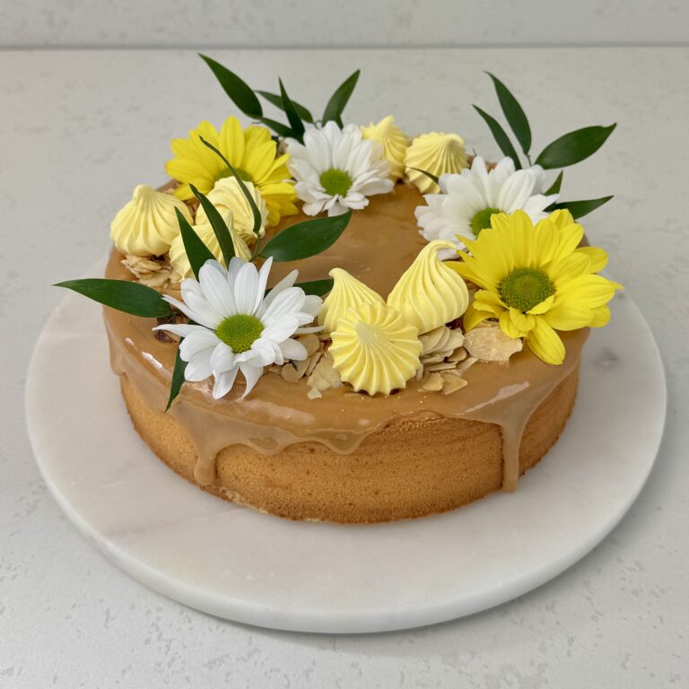 Zdjęcie przedstawia sernik wiedeński z kajmakiem w świątecznej odsłonie. Sernik można zamówić przez sklep cukierni Bezownia znajdującej się w Warszawie, ul. F. Joliot-Curie 11.