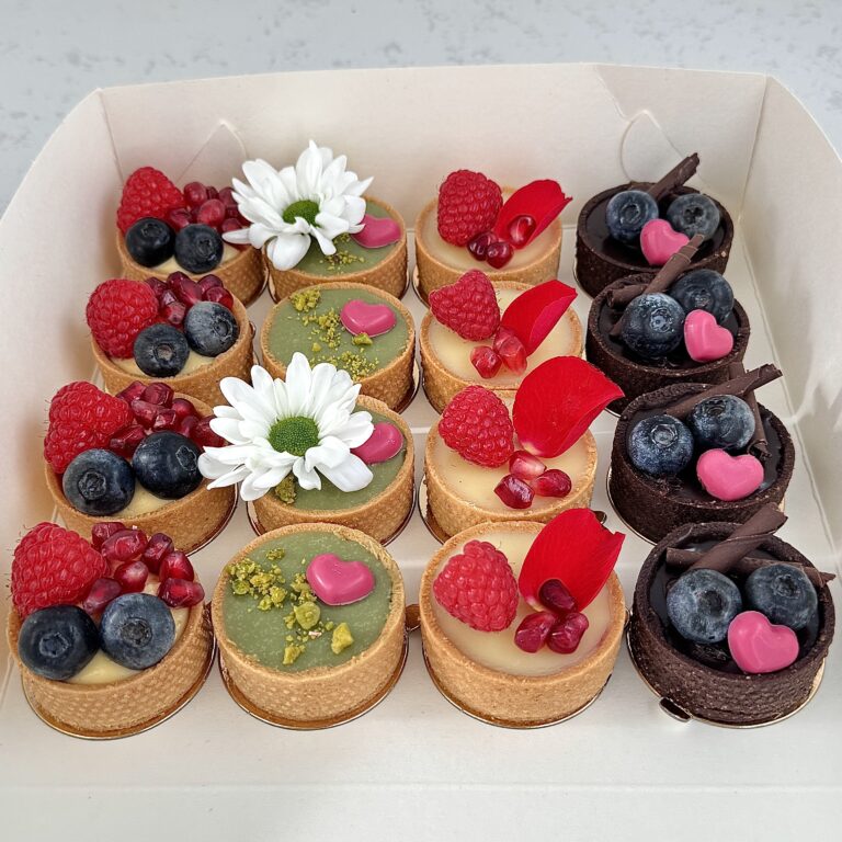 Zdjęcie przedstawia zestaw 16 mini tartaletek - zestaw możliwy do zamówienia przez sklep cukierni Bezownia znajdującej się w Warszawie, ul. F. Joliot-Curie 11.